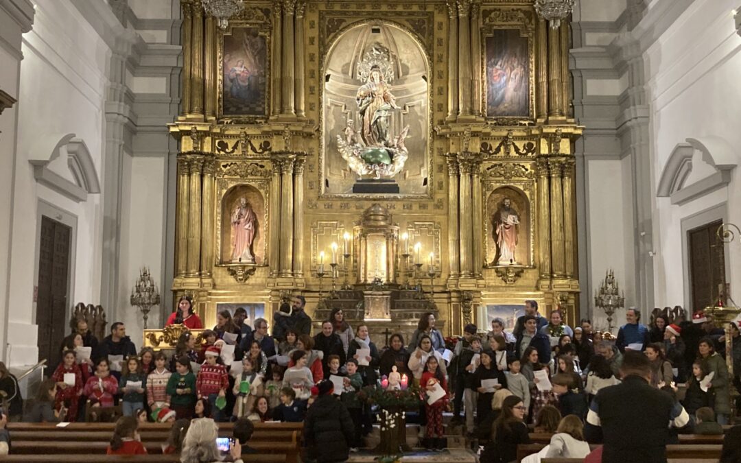 Catequistas, padres y niños cantan al niño Jesús en la parroquia